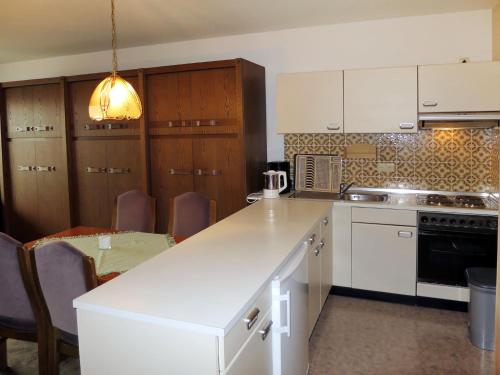 ホークジールにあるApartment Cox by Interhomeのキッチン(白いカウンタートップ、木製キャビネット付)