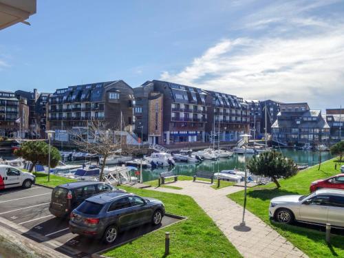 un aparcamiento con coches estacionados junto a un puerto deportivo en Apartment Blue Bay by Interhome en Deauville