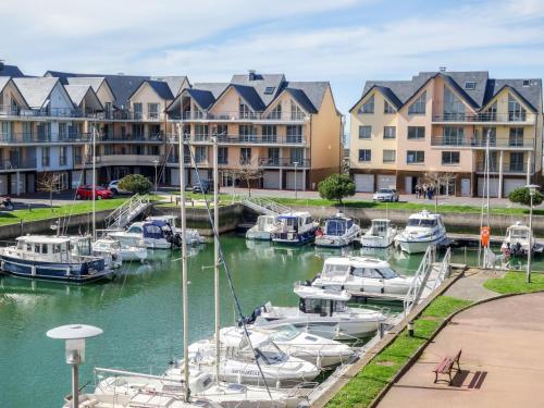 un grupo de barcos atracados en un puerto deportivo con edificios en Apartment Blue Bay by Interhome, en Deauville