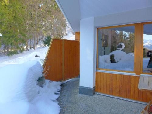 una ventana de una casa con nieve fuera de ella en Studio Terrasse Des Alpes 618 by Interhome, en Crans-Montana