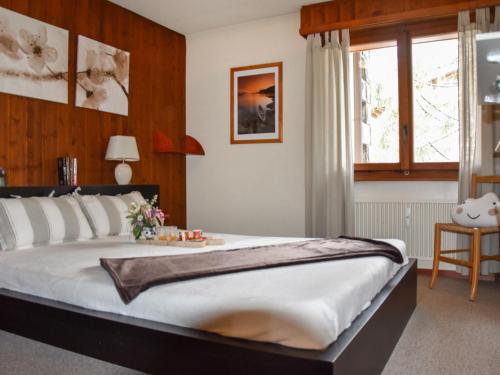 a bedroom with a large bed and a window at Apartment Mondzeu A258 by Interhome in Verbier