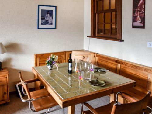 a table with a bottle of wine and flowers on it at Apartment Mondzeu A258 by Interhome in Verbier