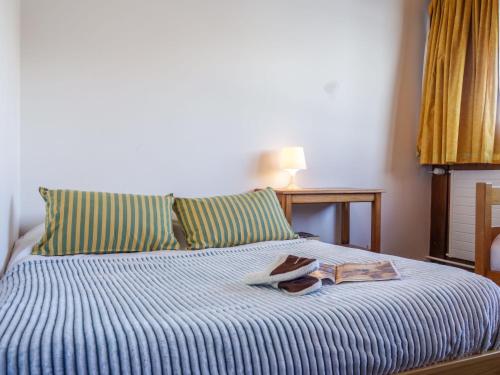 Una cama con un par de zapatos y una toalla. en Apartment La Grande Casse-2 by Interhome en Tignes