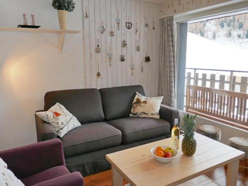 ein Wohnzimmer mit einem Sofa und einem Tisch in der Unterkunft Apartment Dents Rousses E3 by Interhome in Siviez