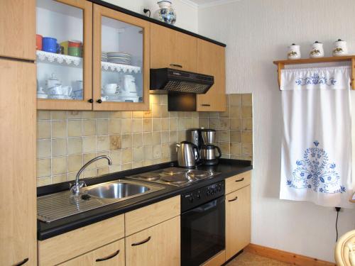 uma cozinha com um lavatório e um fogão forno superior em Apartment Alte Molkerei-1 by Interhome em Friederikensiel