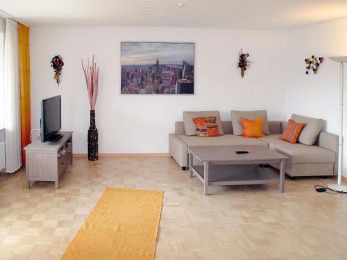 a living room with a couch and a tv at Apartment Vogesenblick by Interhome in Heiligenzell