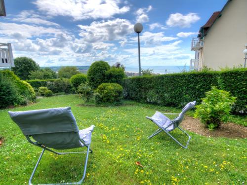 dos sillas sentadas en el césped en un patio en Apartment Le Cap Bleu by Interhome, en Blonville-sur-Mer