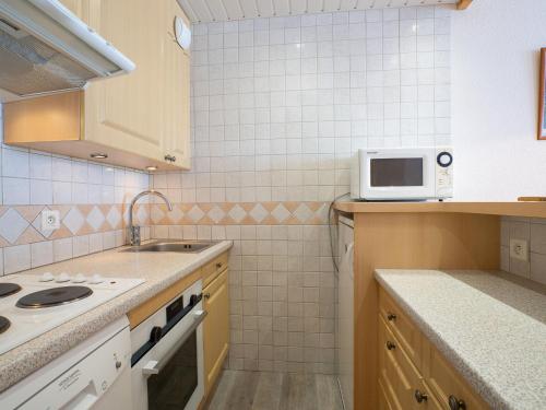 a small kitchen with a sink and a microwave at Apartment Les Tommeuses - Val Claret-17 by Interhome in Tignes