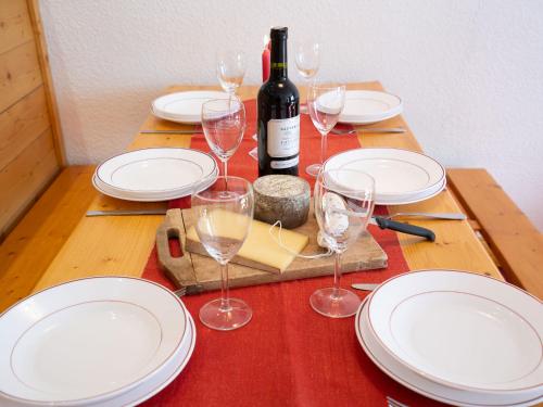 - une table en bois avec des assiettes blanches et des verres à vin dans l'établissement Apartment Les Tommeuses - Val Claret-17 by Interhome, à Tignes