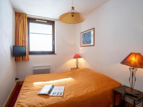 a bedroom with a bed with a book on it at Apartment Les Tommeuses - Val Claret-17 by Interhome in Tignes