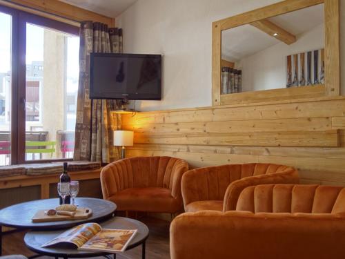 un salon avec deux chaises et une télévision dans l'établissement Apartment Le Grand Tichot A et B - Val Claret-9 by Interhome, à Tignes