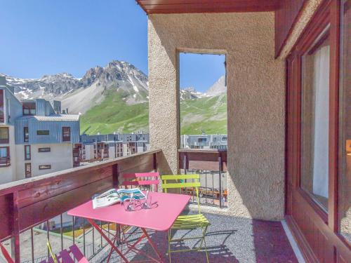a pink table and chairs on a balcony with mountains at Apartment Le Grand Tichot A et B - Val Claret-9 by Interhome in Tignes