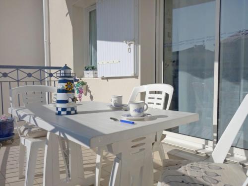 ポンタィヤックにあるApartment Terrasses de Pontaillac by Interhomeの白いダイニングテーブル(白い椅子付)、青と白の中心