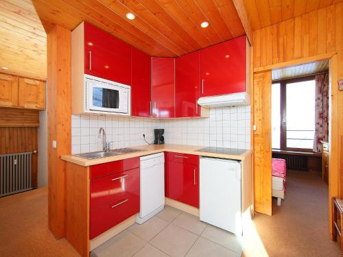 a red kitchen with a sink and a microwave at Apartment Les Hauts du Val Claret-6 by Interhome in Tignes