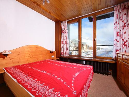 - une chambre avec un lit rouge et de grandes fenêtres dans l'établissement Apartment Les Hauts du Val Claret - Val Claret-6 by Interhome, à Tignes