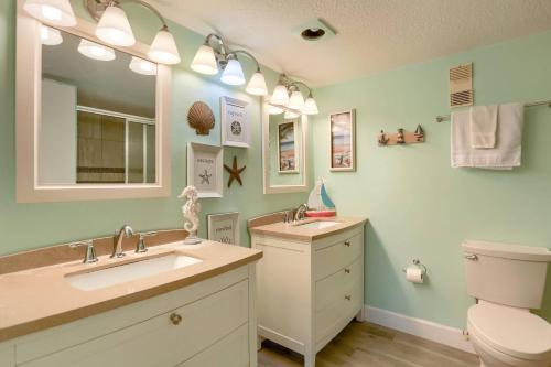 een badkamer met 2 wastafels, een toilet en een spiegel bij 1 Pipers Nest in Clearwater Beach