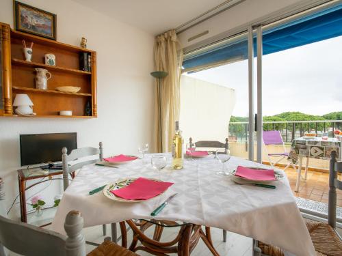 a dining room with a table and a large window at Apartment Les Jardins du Port-4 by Interhome in Le Grau-du-Roi