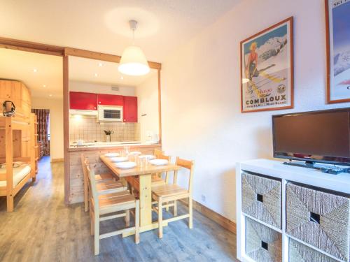 a dining room with a table with chairs and a television at Apartment Le Curling A-2 by Interhome in Tignes