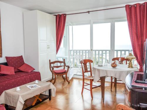 un salon avec un canapé rouge et une table avec des chaises dans l'établissement Studio Le Parc de La Jacotte-3 by Interhome, à Trouville-sur-Mer