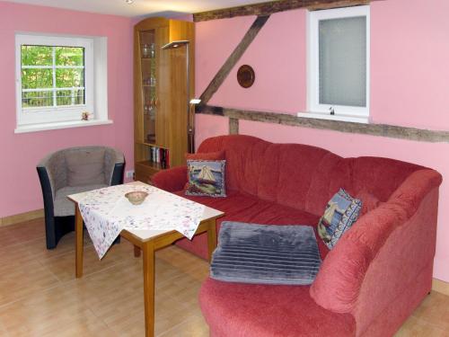 UmmanzにあるHoliday Home Kiebitz by Interhomeのリビングルーム(赤いソファ、テーブル付)