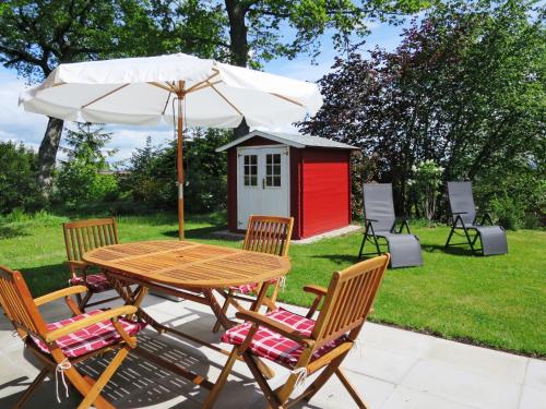 a table and chairs with an umbrella and a smallshed at Holiday Home Svea by Interhome in Wilhelmsdorf
