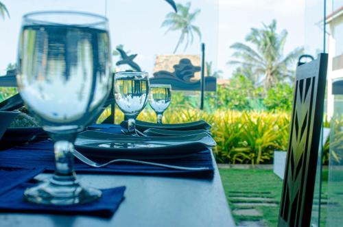 a table with two wine glasses on top of it at Calypso Sunset in Iranawila
