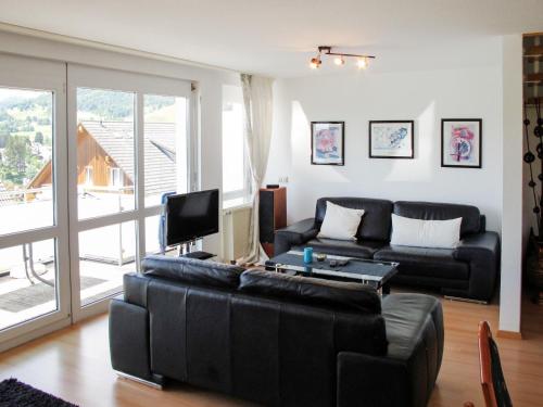 uma sala de estar com um sofá preto e uma televisão em Apartment Schwarzwaldblick IV by Interhome em Bernau im Schwarzwald