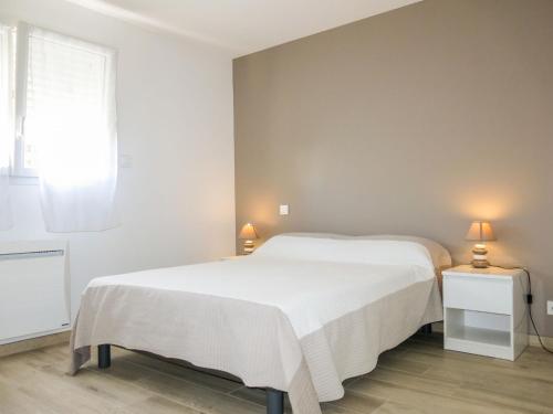 een slaapkamer met een wit bed en een raam bij Holiday Home Les Volets Bleus by Interhome in La Turballe