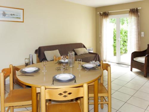 une salle à manger avec une table, des chaises et un canapé dans l'établissement Holiday Home Les Grandes Iles by Interhome, à Pénestin