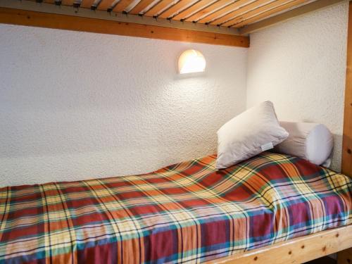 - un lit avec une couverture et des oreillers colorés dans l'établissement Apartment Home Club - Lavachet-1 by Interhome, à Tignes