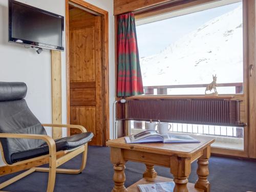 a living room with a chair and a table and a window at Apartment La Grande Casse - Lavachet-3 by Interhome in Tignes