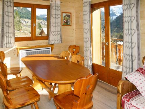 jadalnia z drewnianym stołem i krzesłami w obiekcie Apartment Le Petit Savoyard - CHL405 by Interhome w mieście Châtel