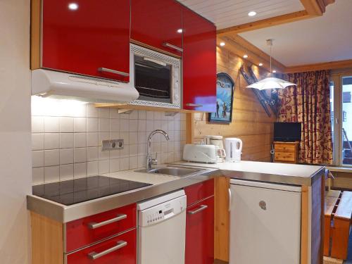ティーニュにあるApartment Le Grand Tichot A et B-8 by Interhomeのキッチン(赤いキャビネット、シンク付)