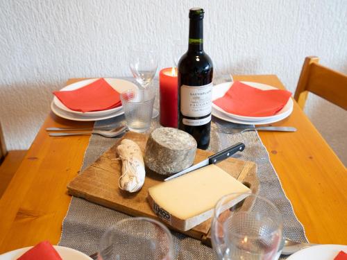 - une table en bois avec une bouteille de vin et du fromage dans l'établissement Apartment Les Grandes Platières II by Interhome, à Tignes