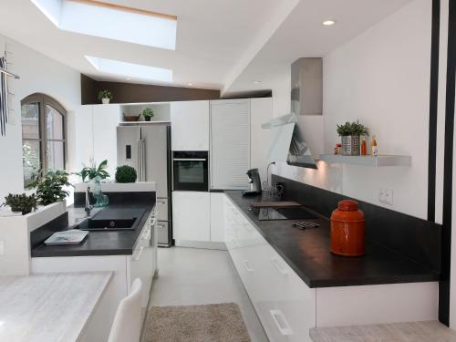 a kitchen with white cabinets and black counter tops at Holiday Home La Chartreuse by Interhome in La Môle