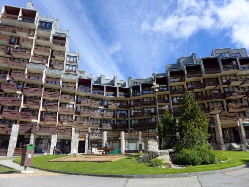 un grand immeuble d'appartements avec une pelouse devant lui dans l'établissement Apartment Le Curling A - Val Claret-12 by Interhome, à Tignes