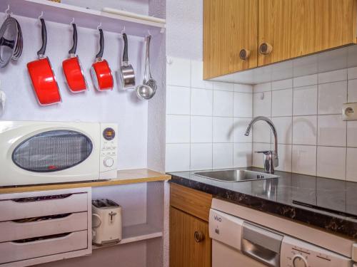 une cuisine avec un micro-ondes et un évier dans l'établissement Apartment Rond Point des Pistes - Val Claret-3 by Interhome, à Tignes