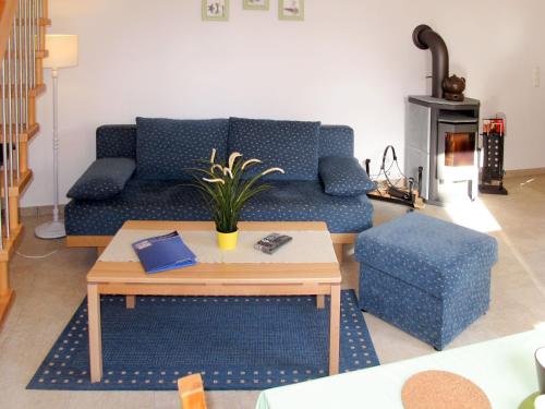 a living room with a blue couch and a table at Holiday Home Ella by Interhome in Zinnowitz