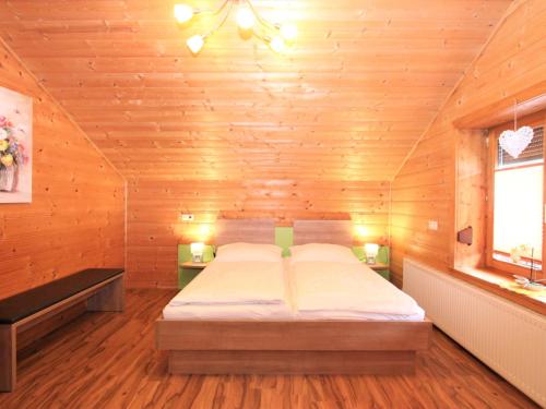um quarto com uma cama num quarto de madeira em Apartment Heidi-3 by Interhome em Ried im Zillertal