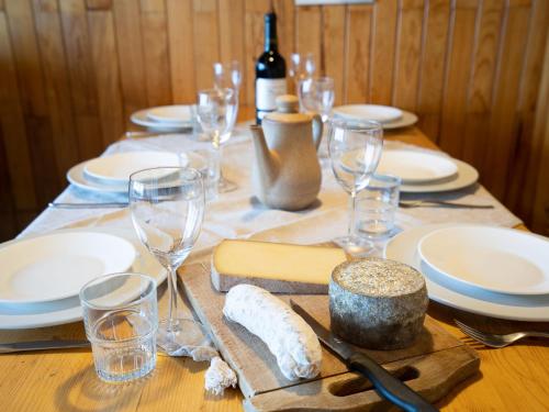 - une table avec des assiettes, des verres à vin et du fromage dans l'établissement Apartment Le Curling B - Val Claret-22 by Interhome, à Tignes