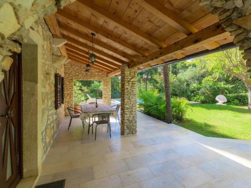 a patio with a table and chairs under a wooden ceiling at Holiday Home Villa Crispo - MDN119 by Interhome in Medulin