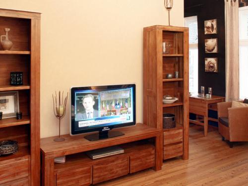 einen Fernseher auf einem hölzernen Entertainment-Center in einem Wohnzimmer in der Unterkunft Apartment Schlüterstrasse by Interhome in Berlin