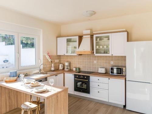 eine Küche mit weißen Schränken und einem weißen Kühlschrank in der Unterkunft Holiday Home Lucija - ZAD730 by Interhome in Pridraga