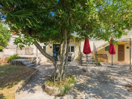 a tree and two umbrellas in front of a house at Holiday Home Danijela by Interhome in Žminj