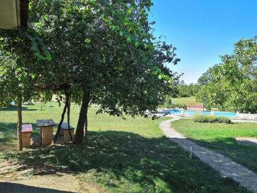 a park with a tree and a bench under a tree at Holiday Home Danijela by Interhome in Žminj