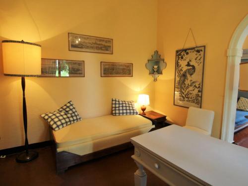 1 dormitorio con sofá, mesa y lámpara en Apartment Bagnolo by Interhome, en Albisola Superiore