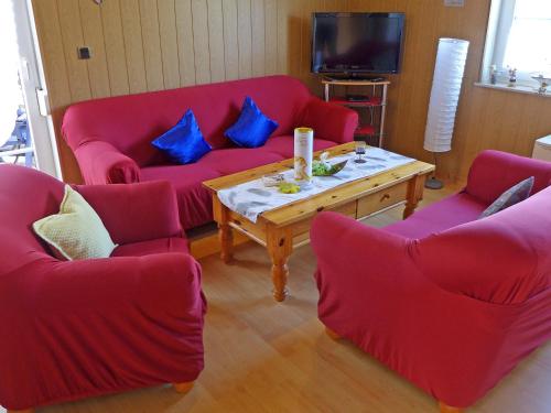 ドルヌマージールにあるHoliday Home Gila by Interhomeのリビングルーム(赤いソファ、コーヒーテーブル付)
