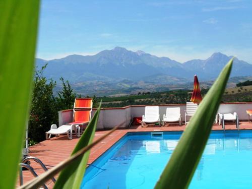 - une piscine avec des chaises et une vue sur les montagnes dans l'établissement Holiday Home Breda by Interhome, à Citta' Sant'Angelo