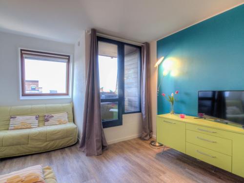 a room with a couch and a tv and a window at Studio Les Marinas-4 by Interhome in Deauville