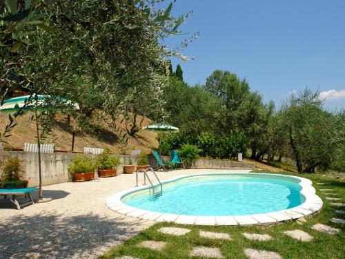 - une petite piscine dans une cour avec un parasol dans l'établissement Apartment I Ceneruzzi-2 by Interhome, à Gambassi Terme